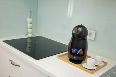 a coffee maker and cups on a tray on a counter at Apartment Sara in Belgrade