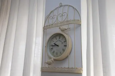 a clock on a wall with two birds on it at Apartment Sara in Belgrade