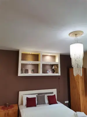 a bedroom with a bed and a chandelier at Airport Apartments in Belgrade