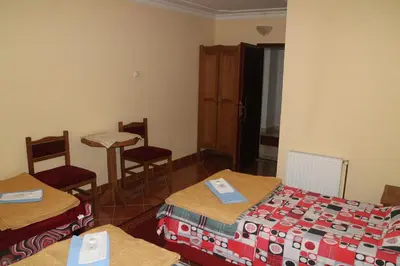 a room with two beds and a table and chairs at Kuca Veljovica in Belgrade