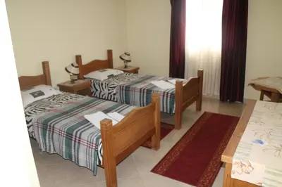 a bedroom with three beds and a table and a table at Kuca Veljovica in Belgrade