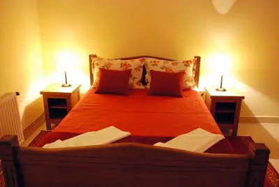a bedroom with a large bed with two lamps at Kuca Veljovica in Belgrade