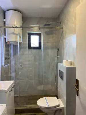 a bathroom with a shower with a toilet and a sink at Apartment Gloria in Belgrade