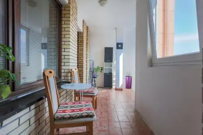 a balcony with two chairs and a table and a window at Apartment Gloria in Belgrade