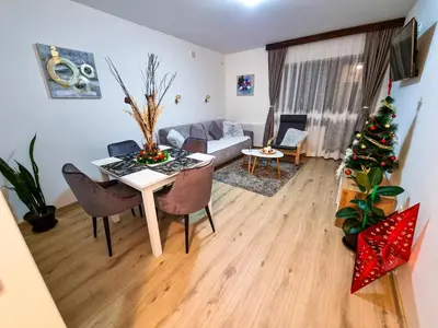 a living room with a table and a christmas tree at Apartmani 