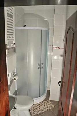 a bathroom with a toilet and a glass shower at Apartmani 