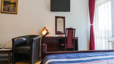 a bedroom with a bed and a chair and a desk at Apartmani 