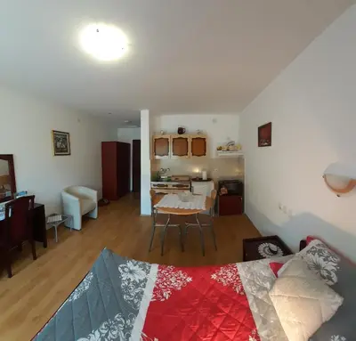 a bedroom and living room with a bed and a table at Apartmani 