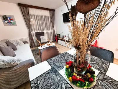 a dining room table with a vase with fruits and vegetables at Apartmani 