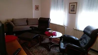 a living room with a couch and a table and chairs at Apartment Krsmanovic in Arandjelovac