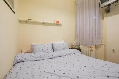 a bedroom with a bed with blue comforter at M&M Downtown Apartment in Belgrade