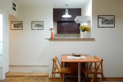 a kitchen with a wooden table and chairs at M&M Downtown Apartment in Belgrade