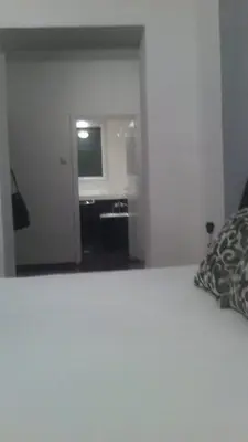 a bedroom with a bed and a room with a television at Apartment Dok in Belgrade
