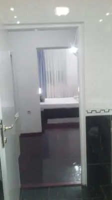 a bathroom with a mirror and a window with a curtain at Apartment Dok in Belgrade
