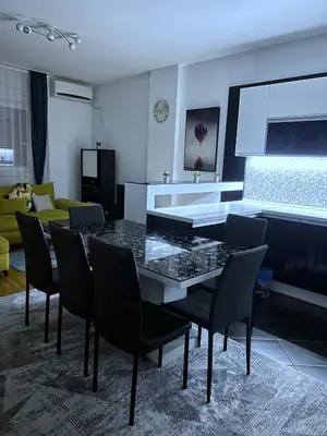 a dining room with a table and chairs and a couch at Pleasure Lux1 Apartment in Belgrade