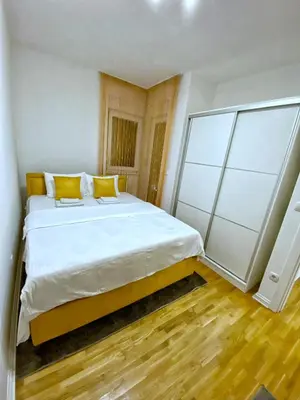 a bedroom with a large white bed with yellow pillows at Pleasure Lux1 Apartment in Belgrade