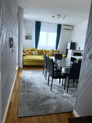 a living room with a table and a yellow couch at Pleasure Lux1 Apartment in Belgrade