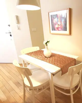 a dining room table and chairs with a vase on it at Apartment Centro in Belgrade