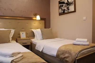 a hotel room with two beds and a picture on the wall at Skadarlija Suites in Belgrade