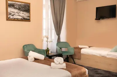 a hotel room with two beds and two chairs at Skadarlija Suites in Belgrade