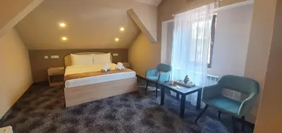 a bedroom with a bed and two chairs and a window at Skadarlija Suites in Belgrade