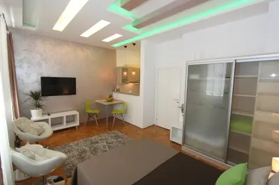 a living room with a television and a room with a table at New Belgrade Apartment IN in Belgrade