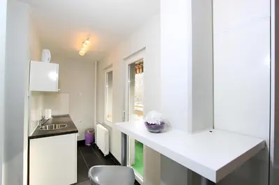 a kitchen with a white counter and a sink at New Belgrade Apartment ARENA in Belgrade