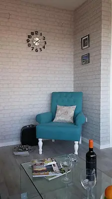 a blue couch in a living room with a clock on the wall at Apartment Savamala Art in Belgrade