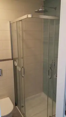 a glass shower with a toilet in a bathroom at Apartment Savamala Art in Belgrade