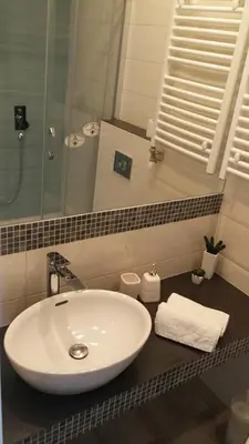 a bathroom with a white sink and a mirror at Apartment Savamala Art in Belgrade