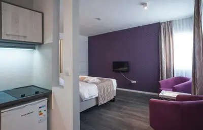 a hotel room with a bed and a purple wall at Apartment Savamala Art in Belgrade