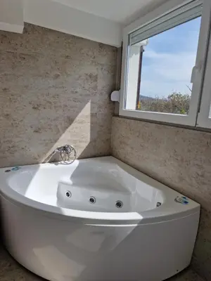 a white bath tub in a bathroom with a window at Rooms Green Set in Belgrade
