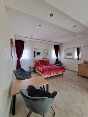 a bedroom with a bed and chairs in a room at Rooms Green Set in Belgrade