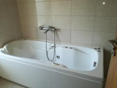 a white bath tub with a shower in a bathroom at Rooms Green Set in Belgrade