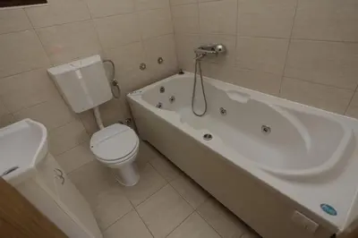 a bathroom with a toilet and a tub and a sink at Rooms Green Set in Belgrade