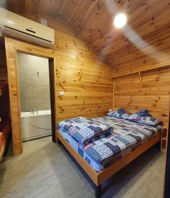 a bedroom with a bed in a wooden cabin at Rooms Green Set in Belgrade