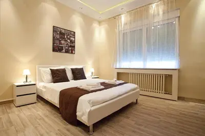 a bedroom with a large bed and a window at Feel Belgrade Bohemian Apartment in Belgrade