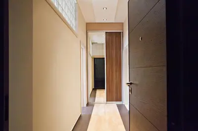 an empty hallway with a door and a window at Feel Belgrade Bohemian Apartment in Belgrade