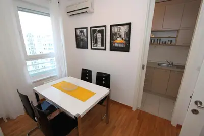 a kitchen with a white table and chairs and a window at New Belgrade apartment Neven, parking 5 evra dan in Belgrade