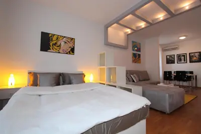 a bedroom with a large white bed and a couch at New Belgrade apartment Neven, parking 5 evra dan in Belgrade