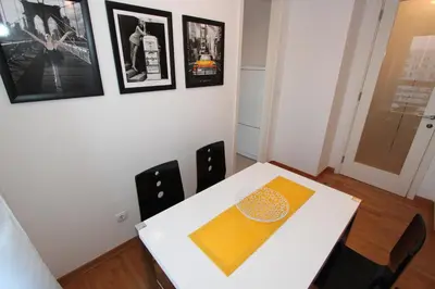 a dining room with a white table and chairs at New Belgrade apartment Neven, parking 5 evra dan in Belgrade