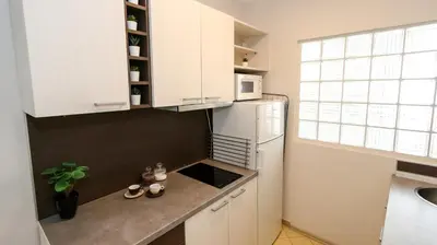 a kitchen with white cabinets and a white refrigerator at DELTA CITY New Belgrade Apartment free public parking in Belgrade