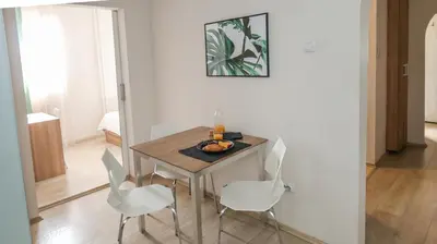 a dining room with a table and white chairs at DELTA CITY New Belgrade Apartment free public parking in Belgrade