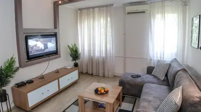 a living room with a couch and a tv at DELTA CITY New Belgrade Apartment free public parking in Belgrade
