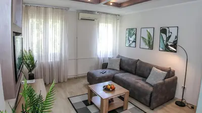 a living room with a couch and a table at DELTA CITY New Belgrade Apartment free public parking in Belgrade
