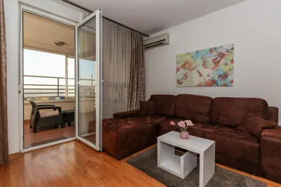a living room with a brown couch and a table at New Belgrade Apartment Lavina, parking 5 evra dan in Belgrade