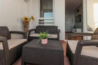 a patio with chairs and a table with a potted plant on it at New Belgrade Apartment Lavina, parking 5 evra dan in Belgrade
