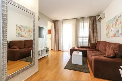 a living room with a brown couch and a mirror at New Belgrade Apartment Lavina, parking 5 evra dan in Belgrade