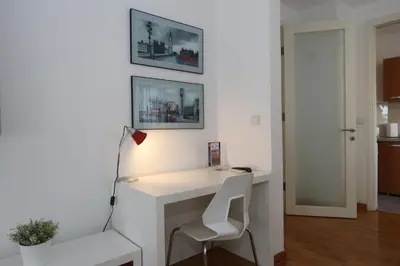 a white desk with a chair and a lamp at New Belgrade Apartment Belville, parking 5 evra dan in Belgrade