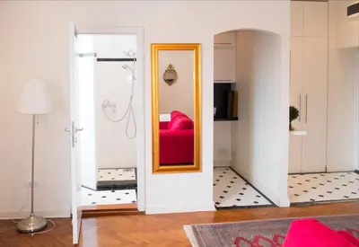a living room with a red couch and a mirror at Belle Apartments - Obilicev Venac in Belgrade
